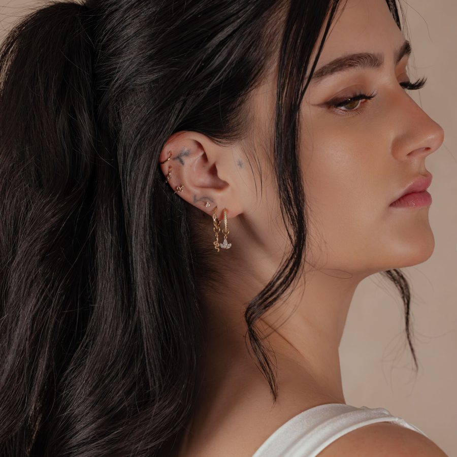 Frau mit 18K Gold Hinged Ring im Ohr, seitliches Profil, dunkles Haar