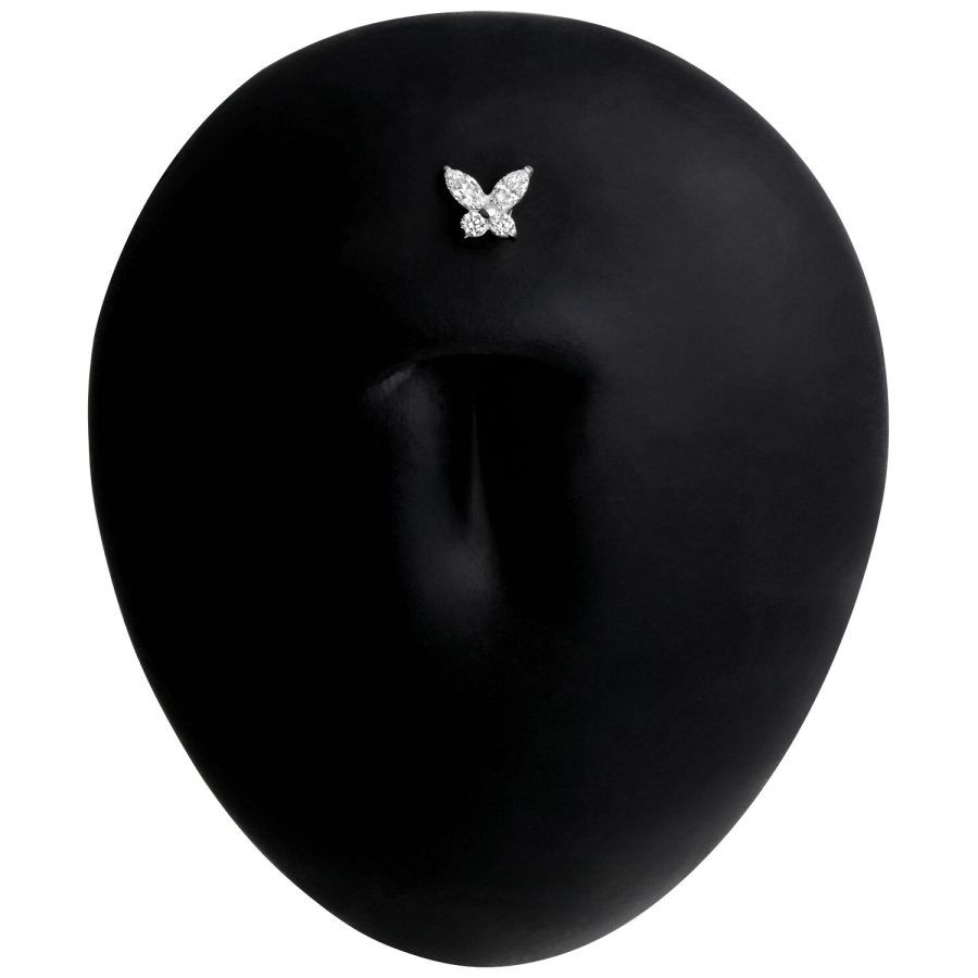Schwarzes Titan Labret Piercing mit Schmetterlingsmotiv auf schwarzem Hintergrund