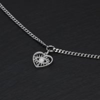Silbernes Armband mit Herzanhänger auf schwarzem Hintergrund