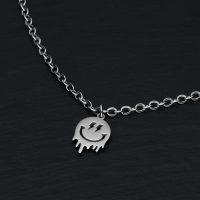 Silbernes Armband mit Smiley-Anhänger auf schwarzem Hintergrund