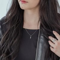 Frau mit langer, dunkler Haaren trägt eine silberne Little Snake Kette und einen schwarzen Lederjacke