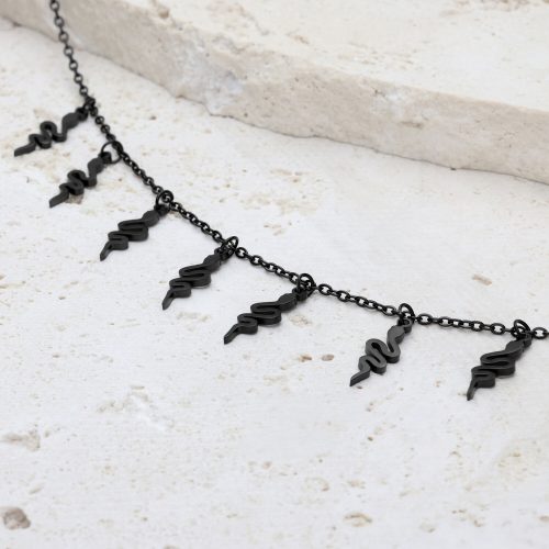 Schwarzes Snake Armband mit verstellbarem Verschluss auf hellem Stein
