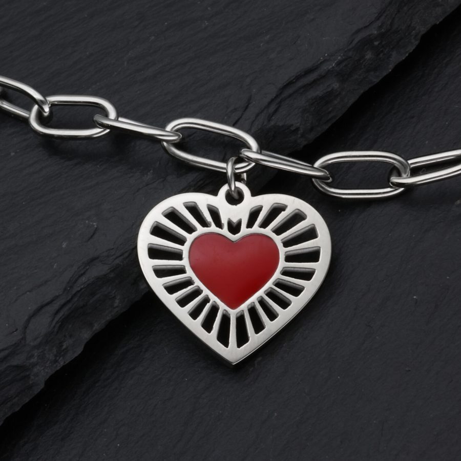 Silberfarbenes Armband mit rotem Herzanhänger auf dunklem Hintergrund