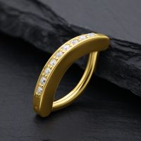 Goldener Bauchnabel Clicker mit Moissanit Kristallen auf schwarzem Hintergrund