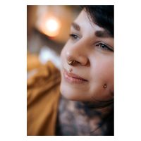 Nahaufnahme einer Person mit Oriental Sun Push-Fit Labret im Nasenpiercing, goldene Farbe
