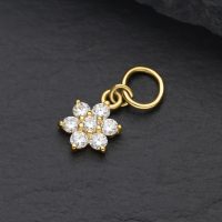Goldener Blütenanhänger aus 18K Gold mit klaren Moissanit-Kristallen auf schwarzem Hintergrund