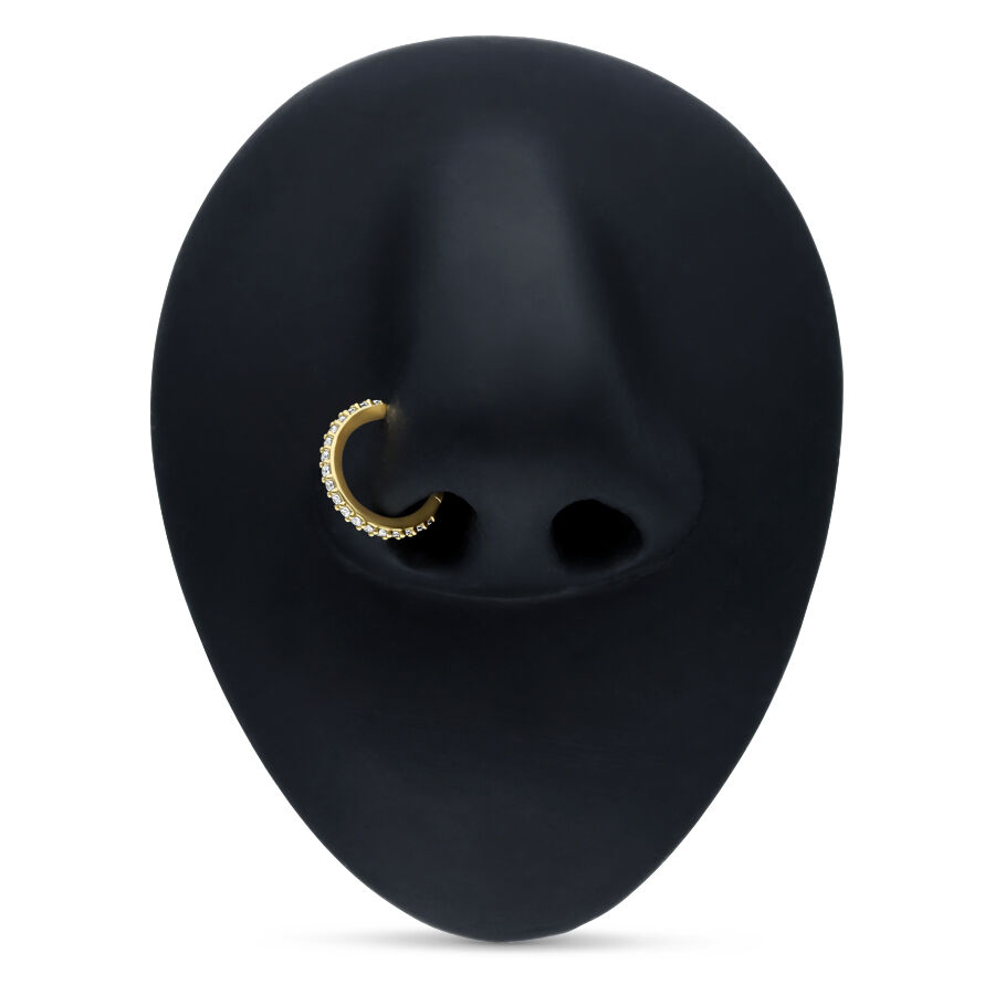 Goldener Piercingring mit Kristallen auf schwarzem Hintergrund