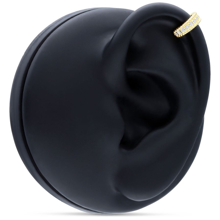 Hinged Ring aus 14K Gold mit Kristallen an einem schwarzen Modell-Ohr