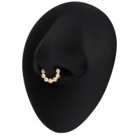 Goldener Septum Piercingring mit Moissanit-Kristallen auf schwarzem Hintergrund