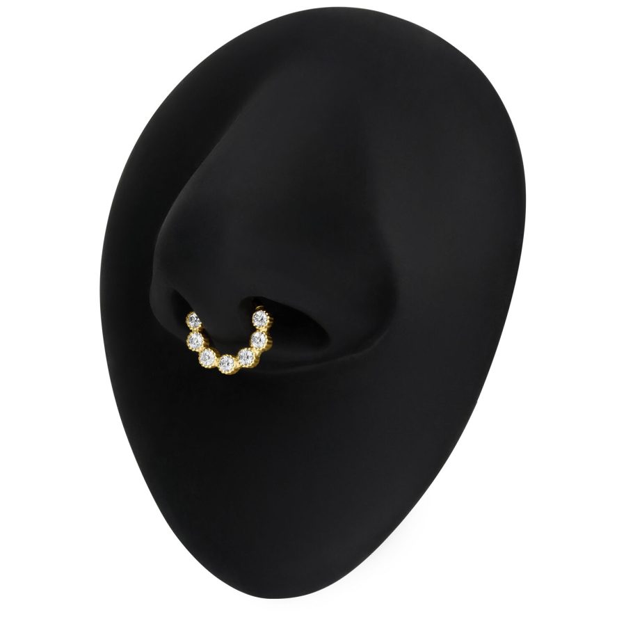 Goldener Septum Piercingring mit Moissanit-Kristallen auf schwarzem Hintergrund