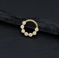 Goldener Piercingring mit funkelnden Moissanit Steinen auf schwarzem Hintergrund