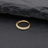 Goldener Nasenring mit Moissanit Kristallen auf schwarzem Stein