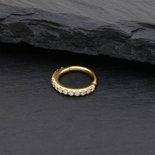 Goldener Nasenring mit Moissanit Kristallen auf schwarzem Stein