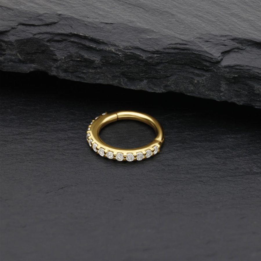 Goldener Nasenring mit Moissanit Kristallen auf schwarzem Stein
