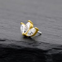 Goldener Lotus-Aufsatz mit klaren Moissanit-Steinen auf schwarzem Hintergrund