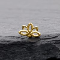Lotusförmiger Aufsatz aus 14K Gold auf grauem Stein