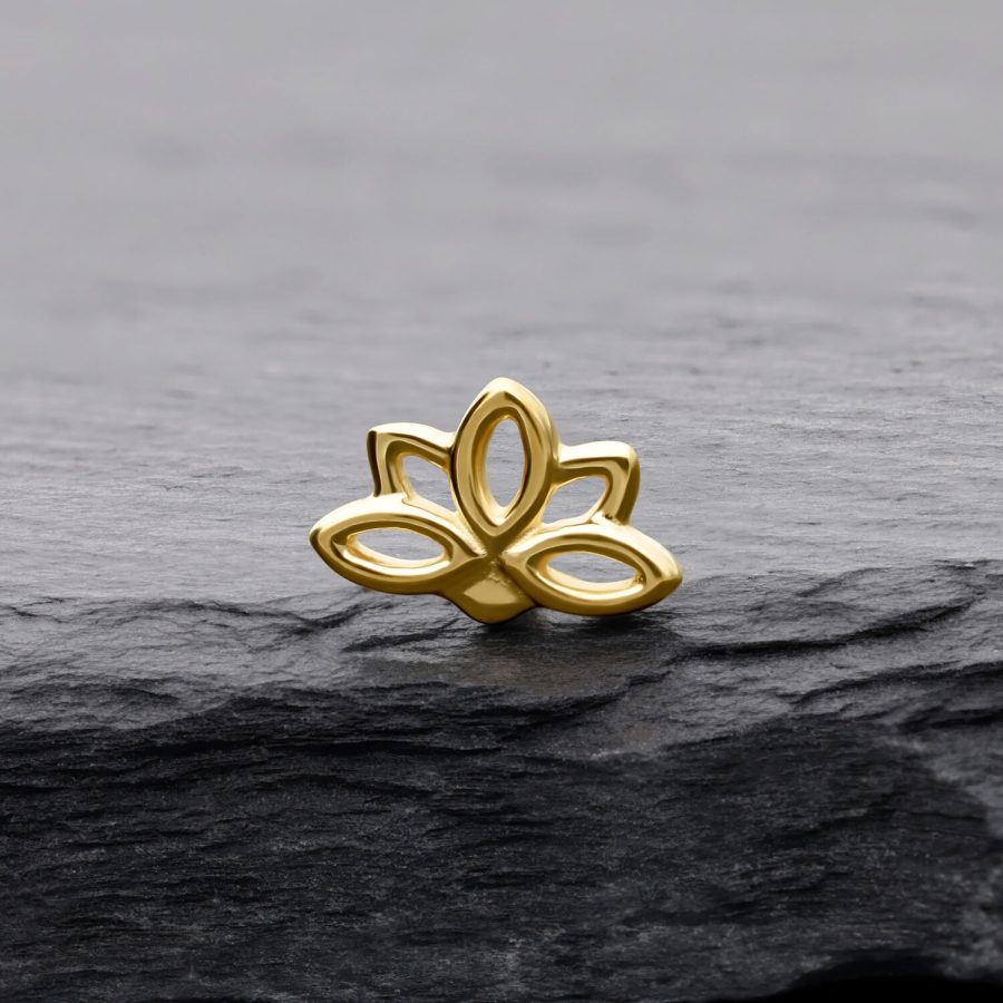 Lotusförmiger Aufsatz aus 14K Gold auf grauem Stein