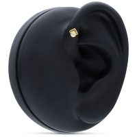 Goldener 14K Piercingaufsatz mit klarem Kristall an einem schwarzen Ohrmodell