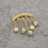 Goldener Piercing-Aufsatz mit fünf klaren Kristalltropfen auf grauem Hintergrund