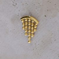 Goldfarbener Helix-Piercing-Aufsatz mit hängenden Kugeln auf hellem Hintergrund