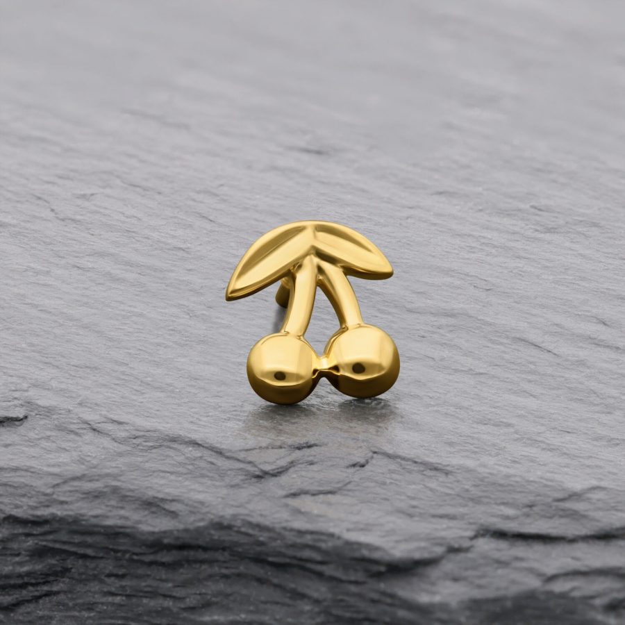 Goldener Kirschenaufsatz aus 14K Gold auf grauem Hintergrund