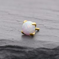 Runder 14K Goldaufsatz mit synthetischem Opal auf grauem Hintergrund