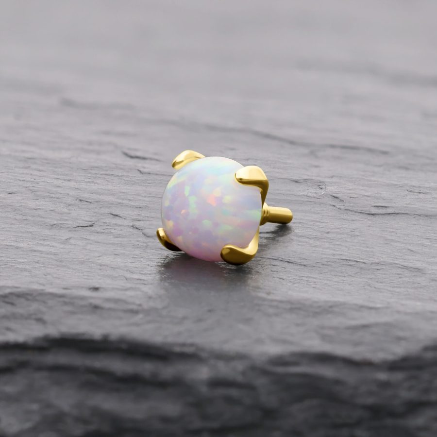 Runder 14K Goldaufsatz mit synthetischem Opal auf grauem Hintergrund