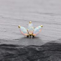 Lotusförmiger Goldaufsatz mit synthetischem Opal auf dunklem Hintergrund