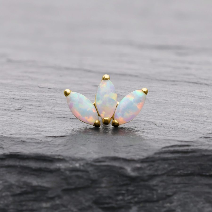 Lotusförmiger Goldaufsatz mit synthetischem Opal auf dunklem Hintergrund