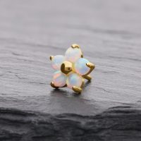 Goldener Blume-Aufsatz mit synthetischem Opal auf grauem Hintergrund