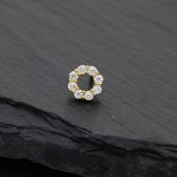 Goldener Piercingaufsatz in Kranzform mit Moissanitsteinen auf schwarzem Hintergrund