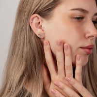 Nahaufnahme eines Ohres mit silbernen Titan-Labret-Kugeln in verschiedenen Größen