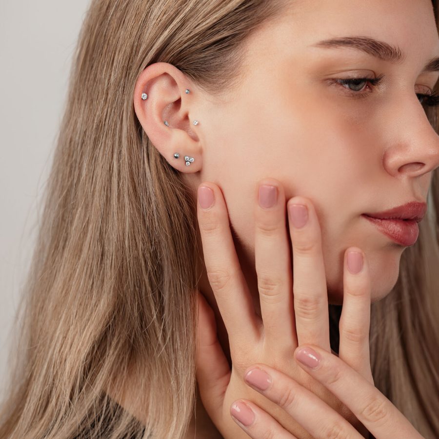 Nahaufnahme eines Ohres mit silbernen Titan-Labret-Kugeln in verschiedenen Größen