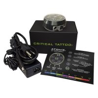 Schwarzes Critical Atomx Netzteil mit Kabel und Bedienungsanleitung auf weißem Hintergrund