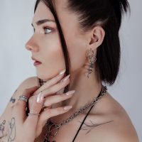 Frau mit silbernen Big Snake Hoops Ohrringen, seitliches Profil