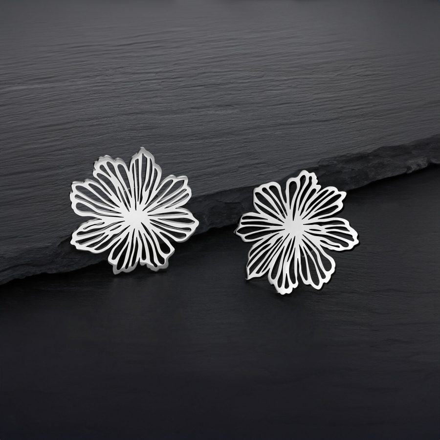 Zwei silberne Blumen Ohrstecker aus Edelstahl auf dunklem Hintergrund