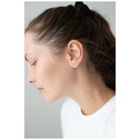 Silberne Ohrstecker mit Kristallen am Ohr einer Frau auf neutralem Hintergrund