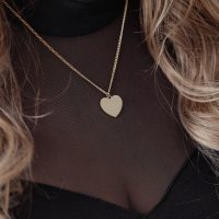 Goldene Herz-Kette an zarter Kette auf schwarzem Oberteil