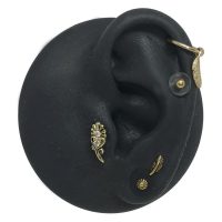 Schwarzes Silikon-Ohrenmodell mit goldenen Piercing-Aufsätzen auf weißem Hintergrund