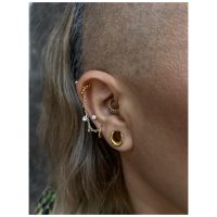 Ohr mit goldener und silberner Piercingkette, klarer Kristall