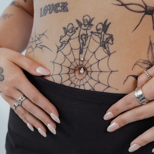 Silbernes Bauchnabel Bananabell mit klarem Kristall auf Bauch mit Tattoos