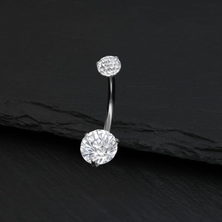 Silbernes Bauchnabelpiercing mit klarem Kristall auf schwarzem Hintergrund