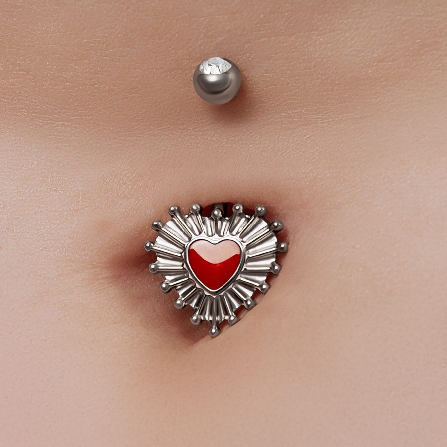 Bauchnabelpiercing mit rotem Herz-Design und silbernen Akzenten auf Haut
