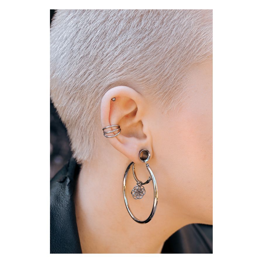 Ohr mit silbernem Tunnel-Piercing und auffälligem Ohrring, kurze Haare