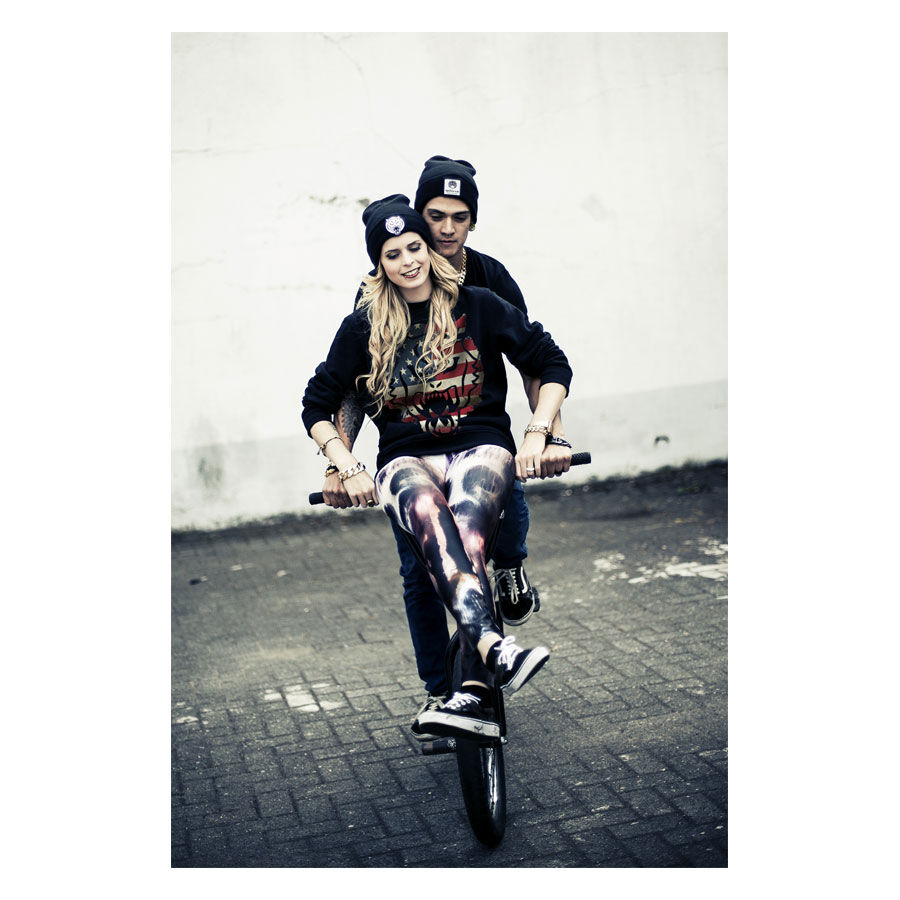 Junge Frau und Mann auf Fahrrad, tragen Wildcat® Sweatshirt in Schwarz mit USA-Design
