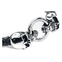Schwarzes Lederarmband mit silbernen Schädeln und Ringverschluss vor weißem Hintergrund