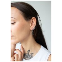 Frau mit schwarzen Little Moonchild Hoops, seitlich im Ohr getragen
