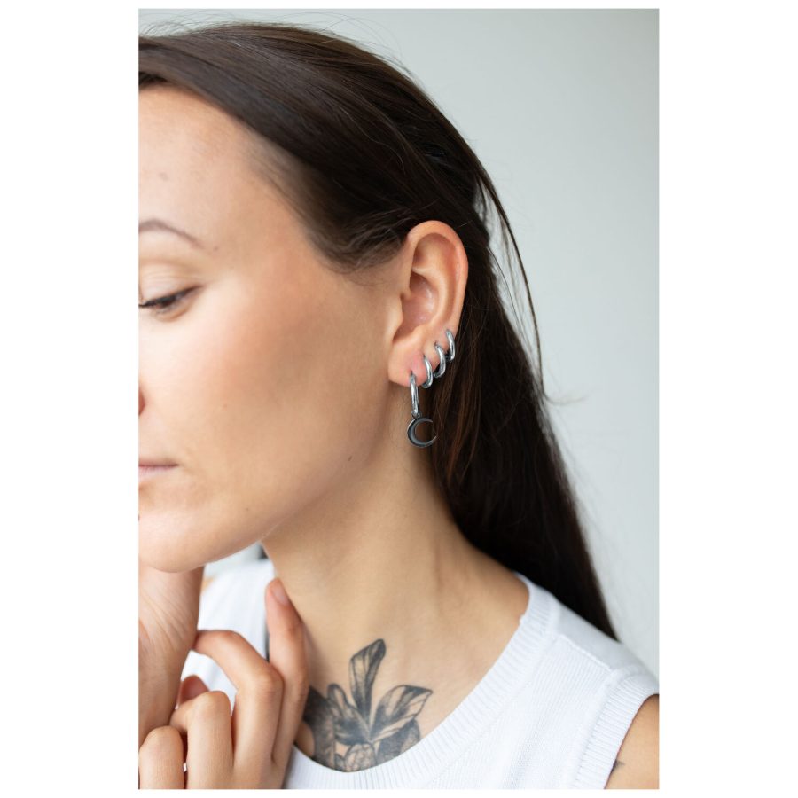Frau mit schwarzen Little Moonchild Hoops, seitlich im Ohr getragen