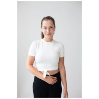 Frau mit weißen Oberteil und schwarzen Hosen trägt silberne Little Cross Hoops vor weißem Hintergrund