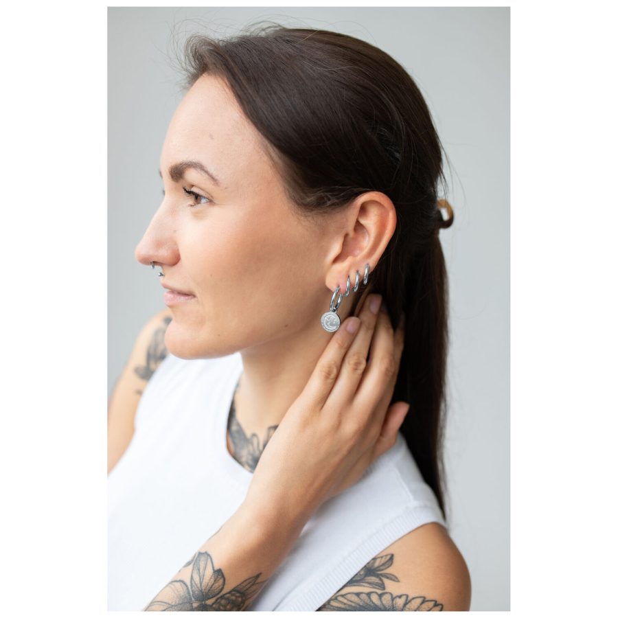 Frau mit langen Haaren trägt silberne Little Sun Moon Hoops Ohrringe